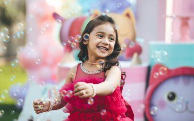 Laimingi vaikai lauke gaudantys didelį kiekį muilo burbulų