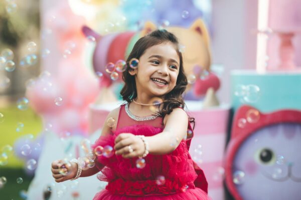 Laimingi vaikai lauke gaudantys didelį kiekį muilo burbulų